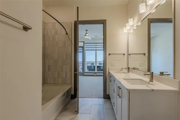 a bathroom with a tub sink and mirror