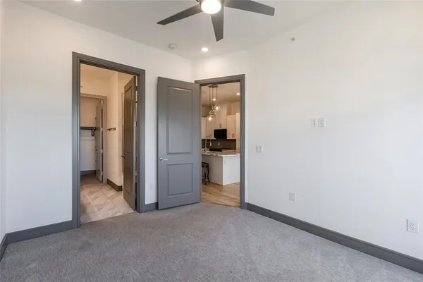 an empty room with closet and a ceiling fan