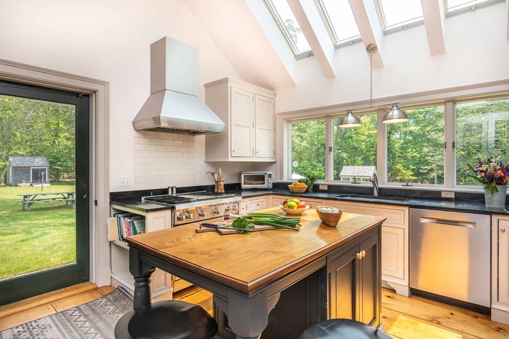 23 Indian Hollow Road West Tisbury, MA 02568 - Photo 15 of 42 a kitchen with a stove a sink a counter top space and living room view