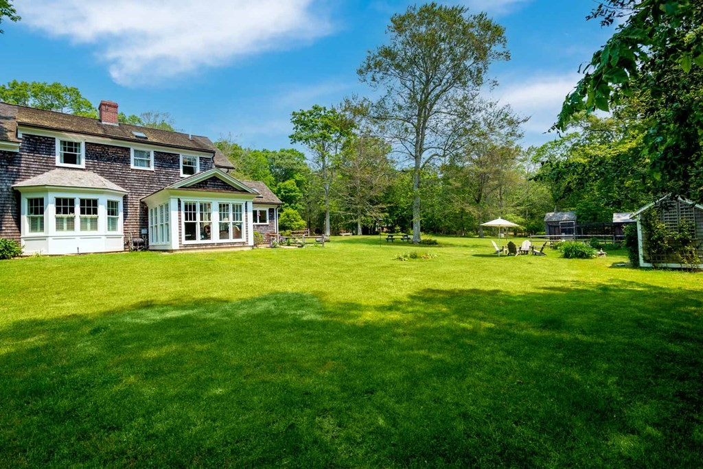 23 Indian Hollow Road West Tisbury, MA 02568 - Photo 4 of 42 a front view of a building with a garden