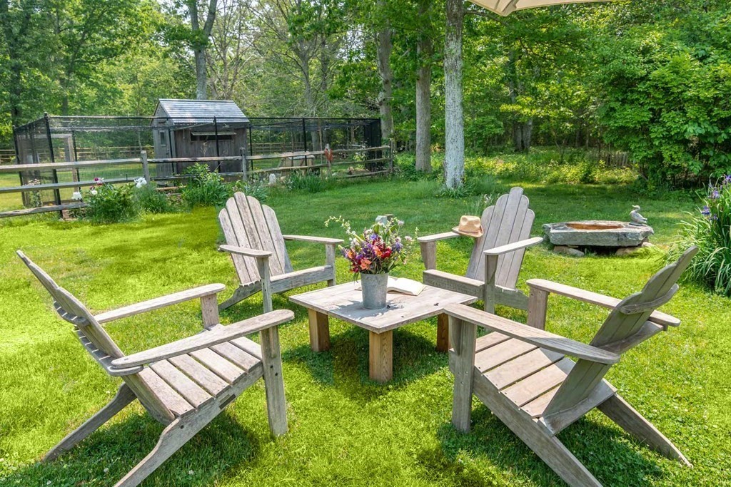23 Indian Hollow Road West Tisbury, MA 02568 - Photo 9 of 42 a view of a chair and table in the garden