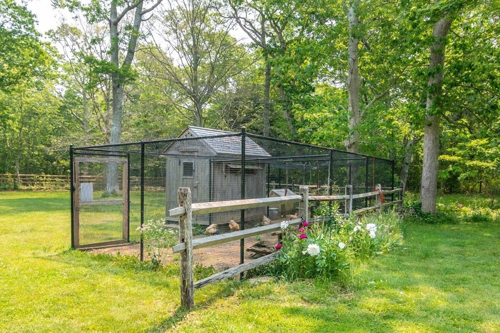 23 Indian Hollow Road West Tisbury, MA 02568 - Photo 10 of 42 a backyard of a house with table and chairs