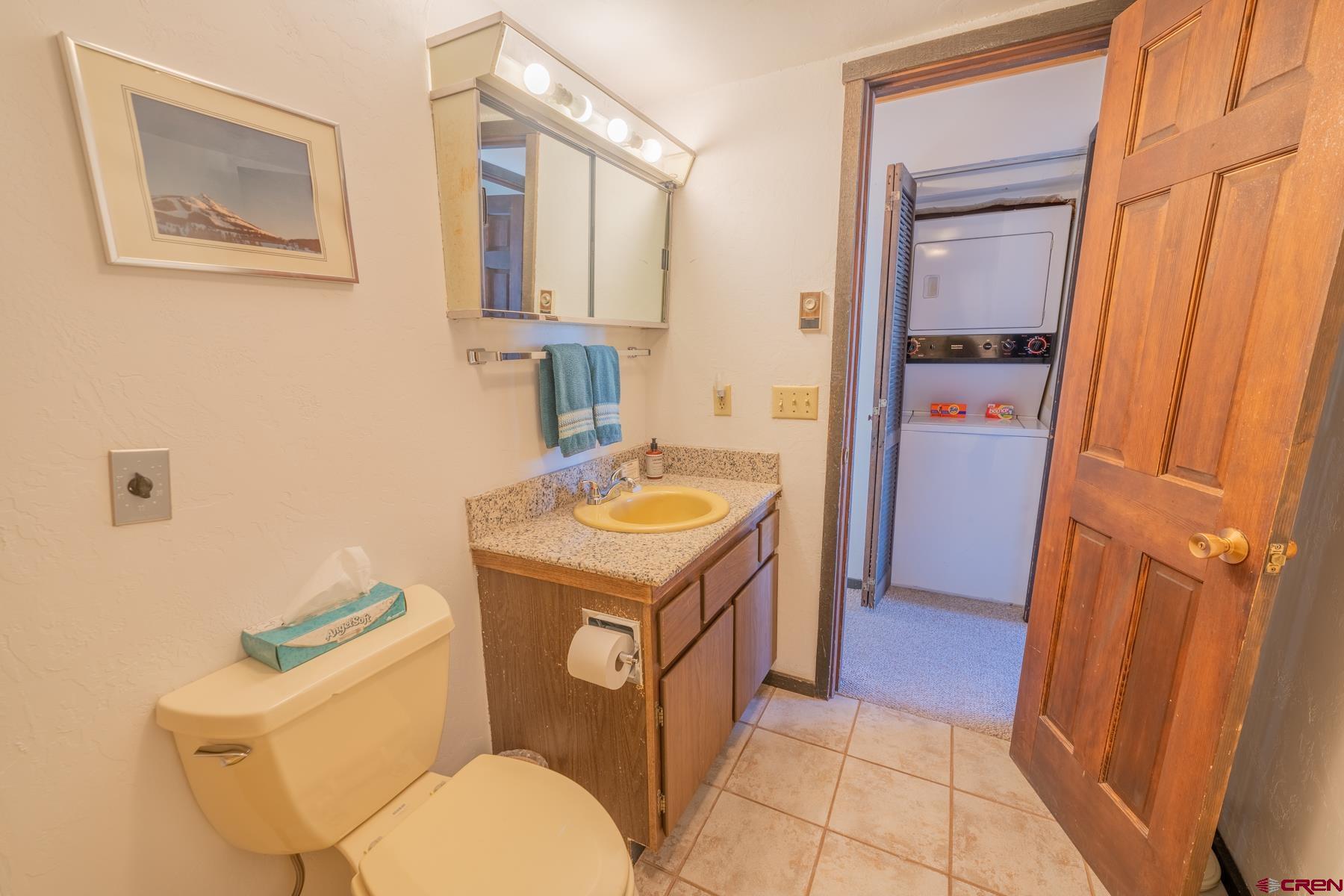 14 Snowmass Road, Unit 301 Crested Butte, CO 81225 - Photo 15 of 35 a bathroom with a granite countertop toilet sink and mirror