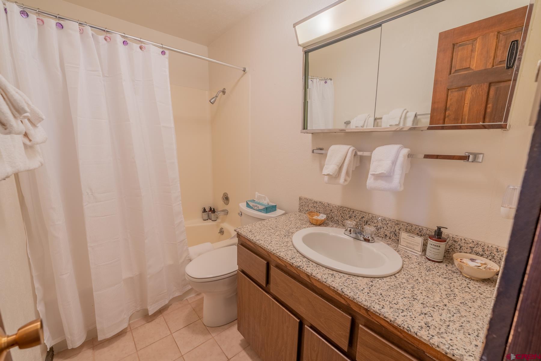 14 Snowmass Road, Unit 301 Crested Butte, CO 81225 - Photo 17 of 35 a bathroom with a granite countertop sink and a mirror