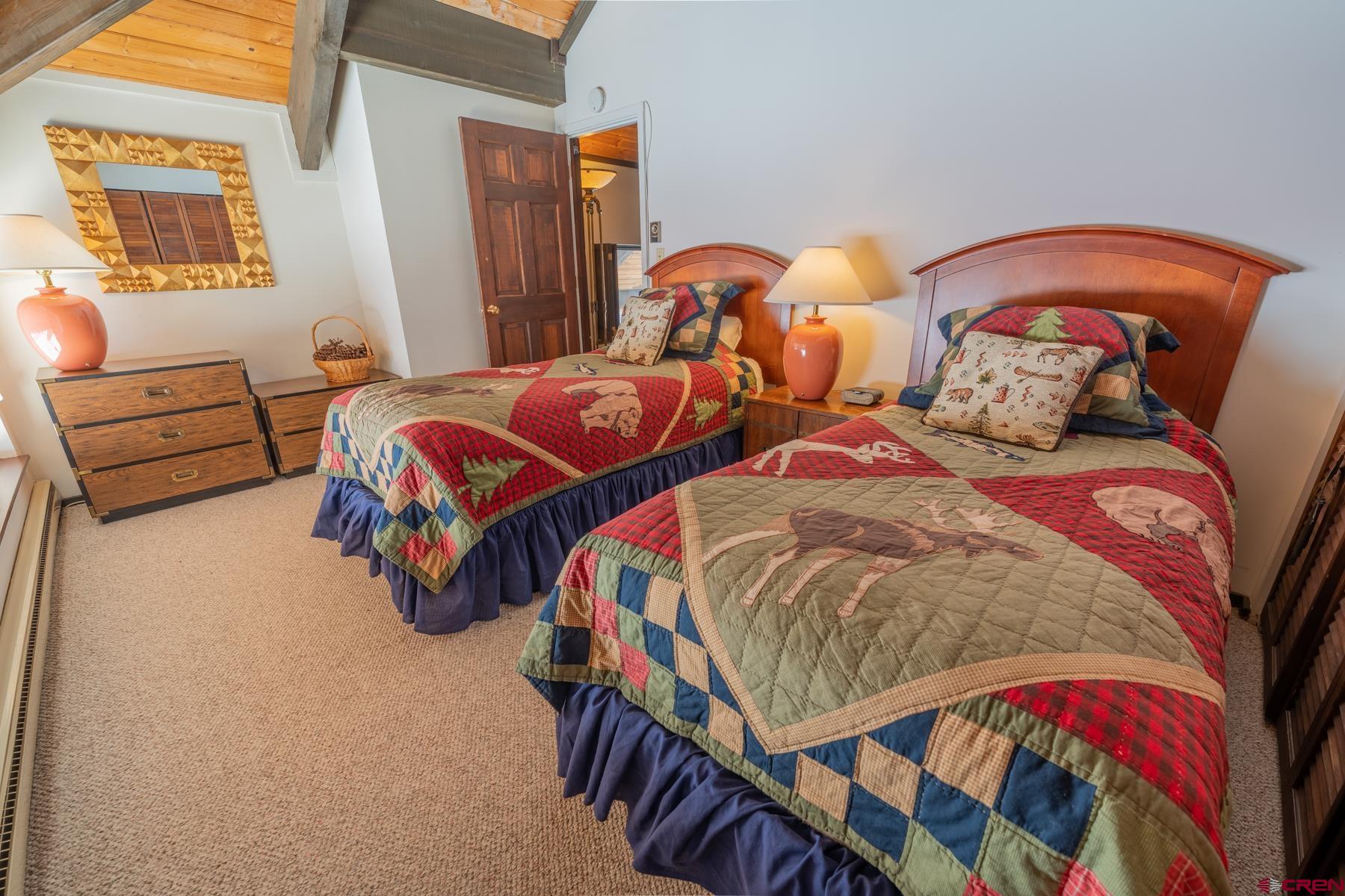 14 Snowmass Road, Unit 301 Crested Butte, CO 81225 - Photo 22 of 35 a bedroom with two beds and a lamp