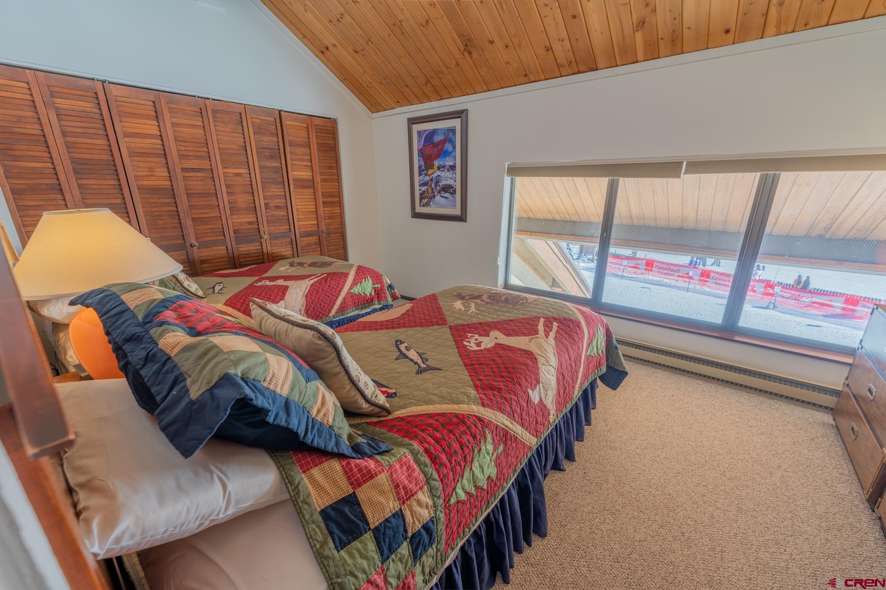14 Snowmass Road, Unit 301 Crested Butte, CO 81225 - Photo 23 of 35 a bed sitting in a bedroom next to a window