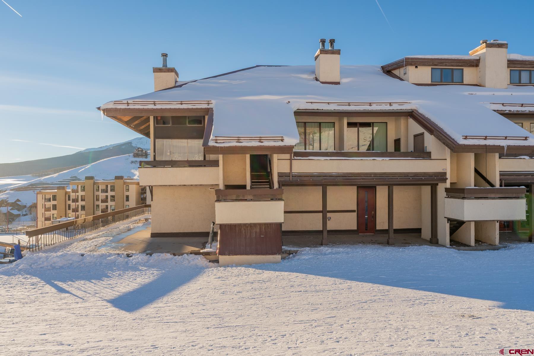 14 Snowmass Road, Unit 301 Crested Butte, CO 81225 - Photo 33 of 35 a front view of a house with a yard