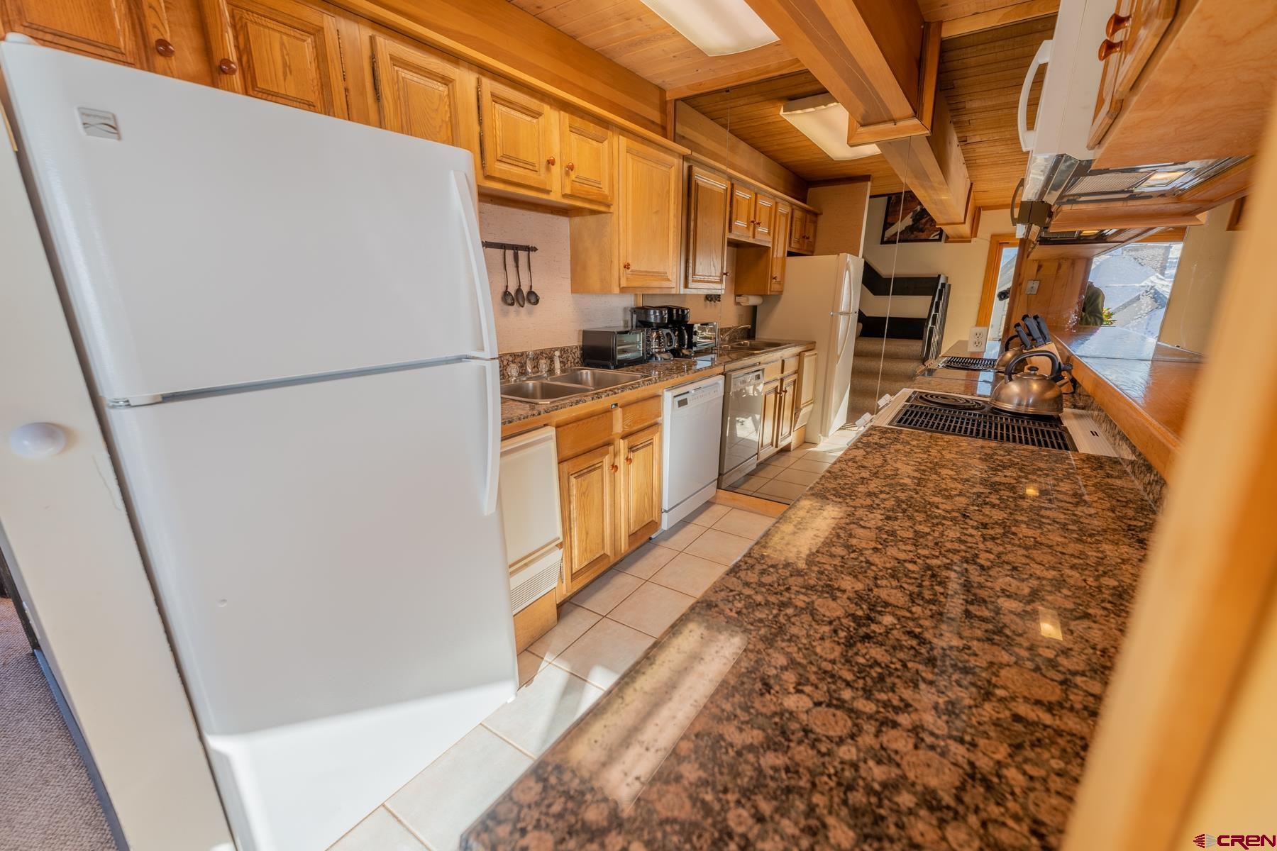 14 Snowmass Road, Unit 301 Crested Butte, CO 81225 - Photo 8 of 35 a kitchen with refrigerator and car
