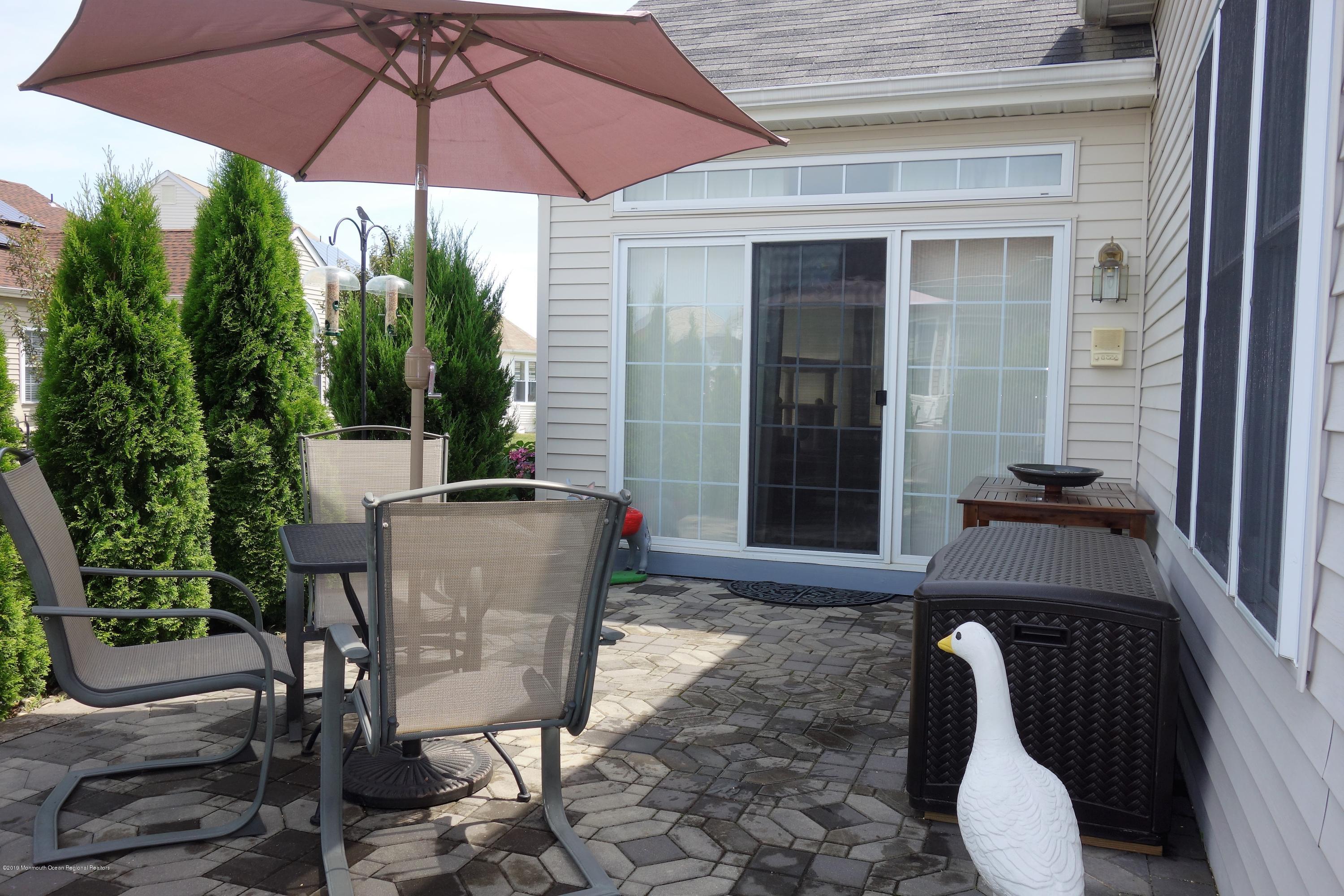 33 Pancoast Road Waretown, NJ 08758 - Photo 26 of 27 a patio with a table and chairs under an umbrella