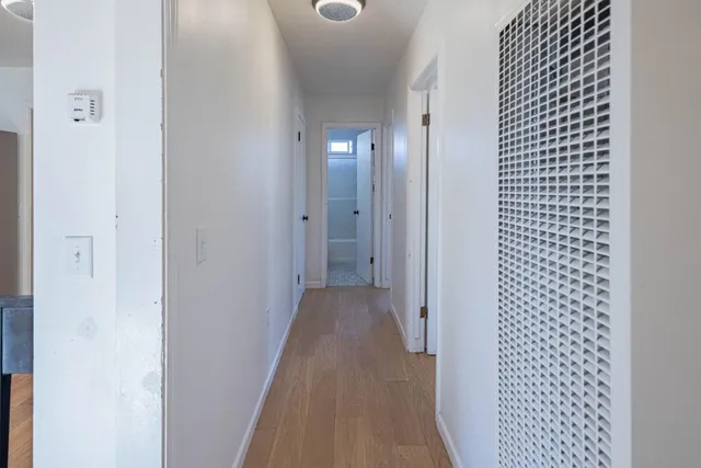a view of a hallway with wooden floor