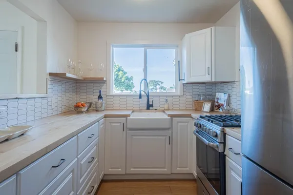 a kitchen with cabinets appliances a sink and a window