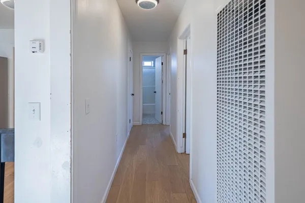 a view of a hallway with wooden floor
