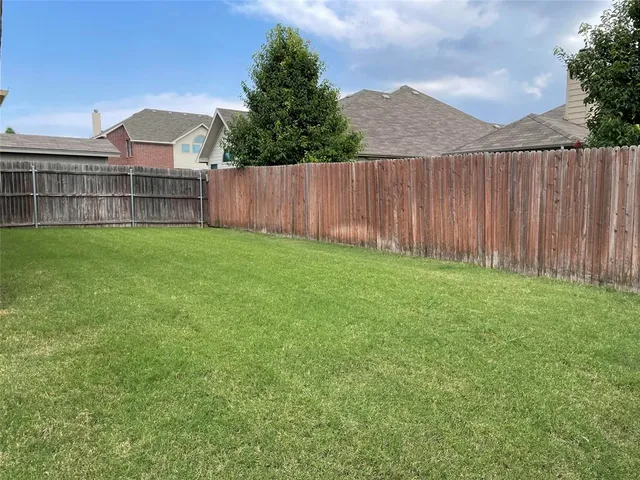 a view of a backyard with wooden fence
