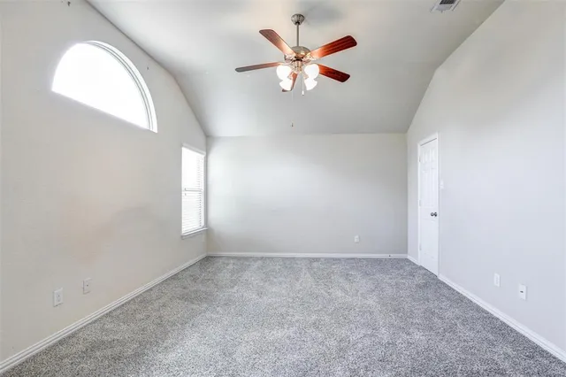 an empty room with windows and fan