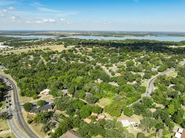 an aerial view of a house with a yard and tree s