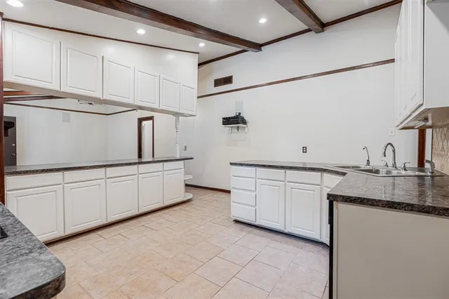 a kitchen with granite countertop white cabinets and white appliances