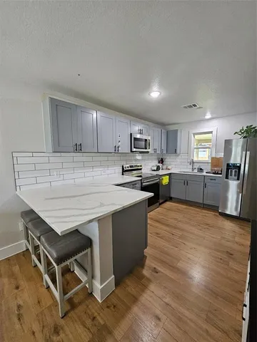 a kitchen with stainless steel appliances granite countertop a stove sink and cabinets