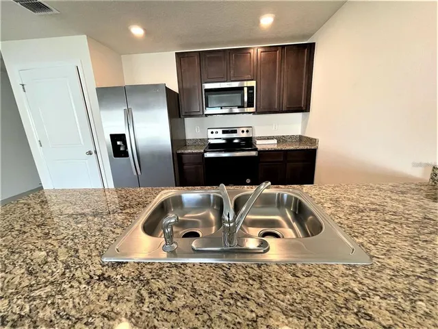 a modern kitchen with stainless steel appliances refrigerator and microwave