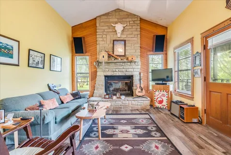 a living room with furniture a fireplace and a floor to ceiling window