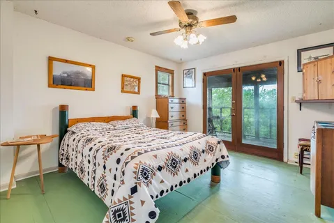 a bedroom with a bed chandelier and a window