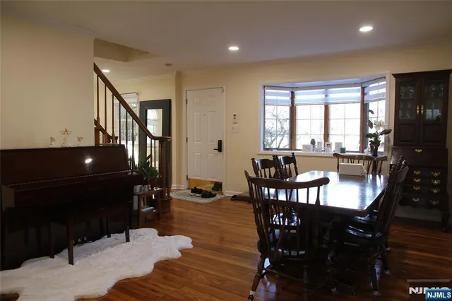 a view of a dining room with furniture a potted plant and wooden floor
