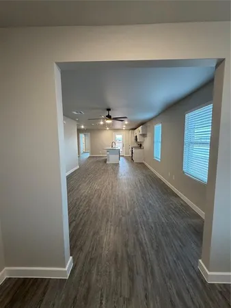 a empty room with wooden floor and windows