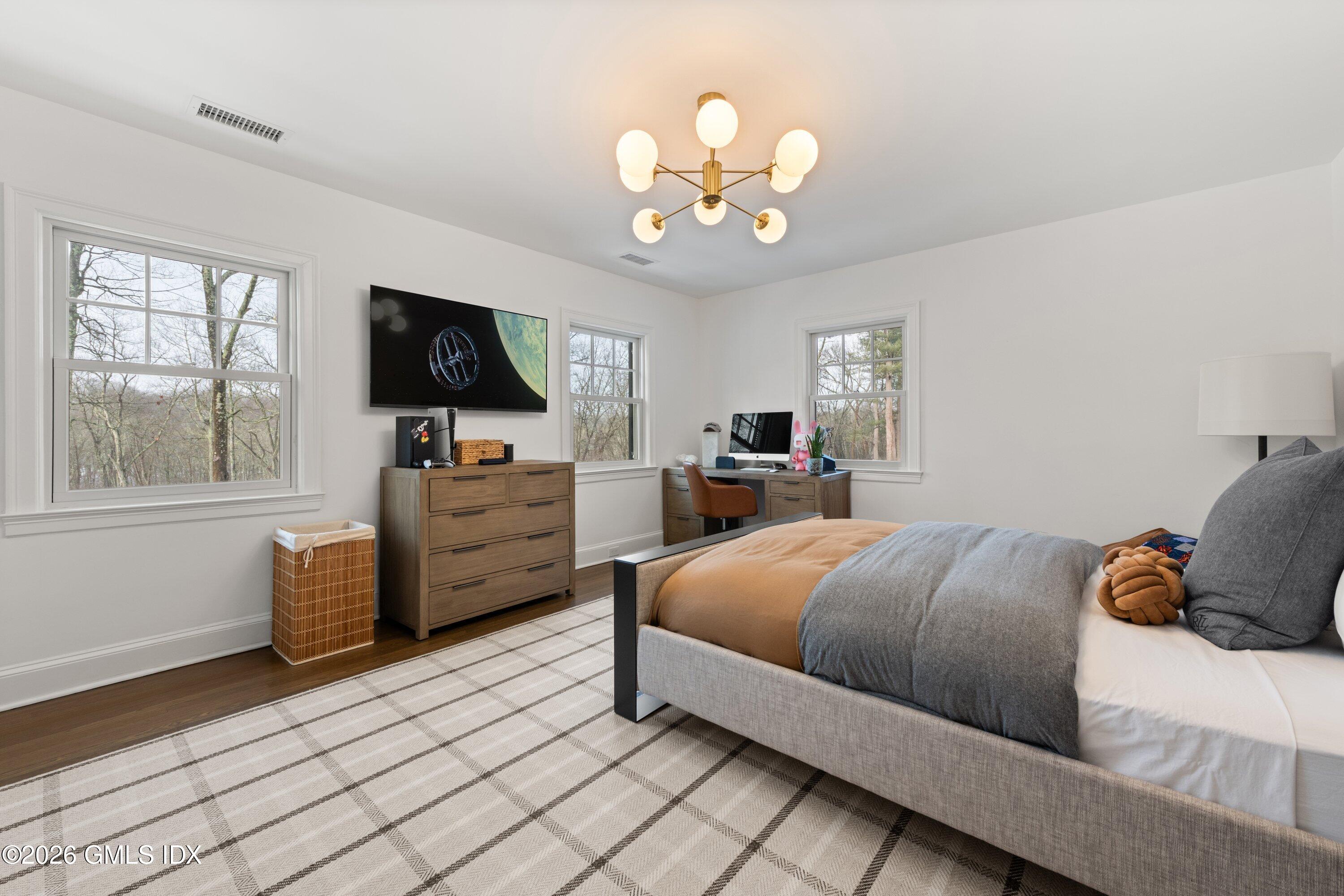 530 Round Hill Road Greenwich, CT 06831 - Photo 32 of 63 a bedroom with a large bed and a flat tv screen on a dresser