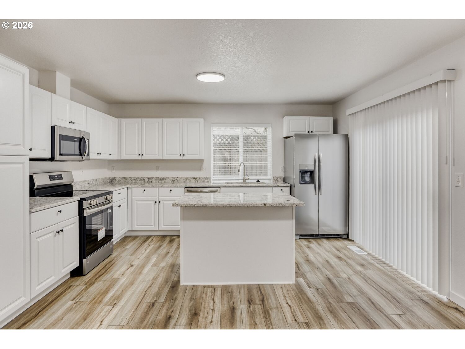 7642 Southwest 205th Terrace Beaverton, OR 97007 - Photo 12 of 28 a kitchen with a refrigerator a sink dishwasher with a dining table and chairs