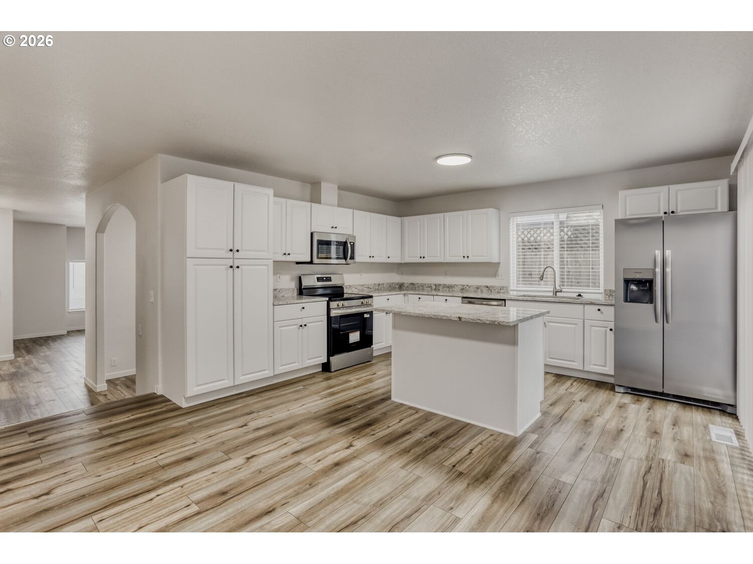 7642 Southwest 205th Terrace Beaverton, OR 97007 - Photo 16 of 28 a kitchen with wooden floors and white appliances