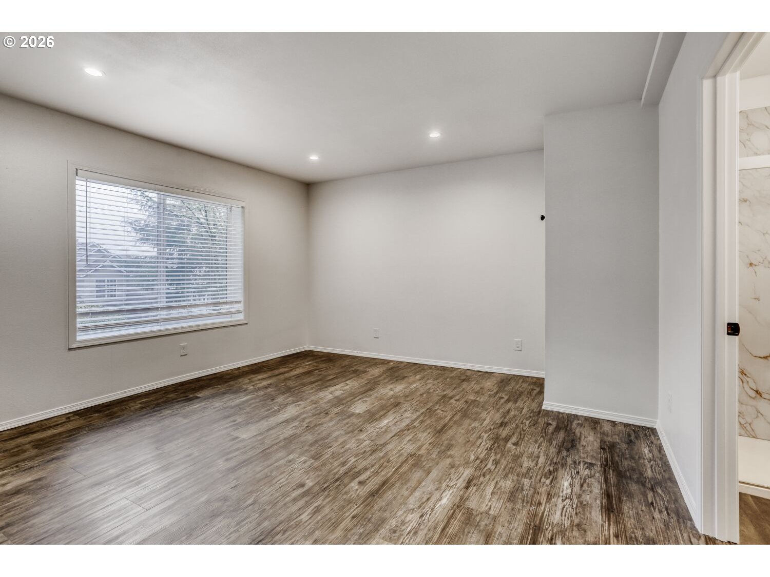7642 Southwest 205th Terrace Beaverton, OR 97007 - Photo 19 of 28 a view of an empty room with wooden floor and a window
