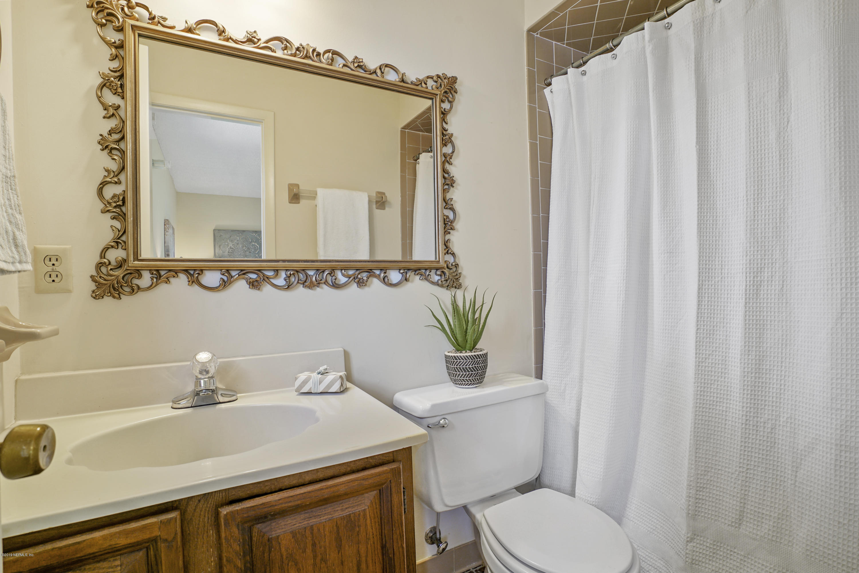 5353 Hickson Road Jacksonville, FL 32207 - Photo 13 of 18 a bathroom with a sink and a mirror