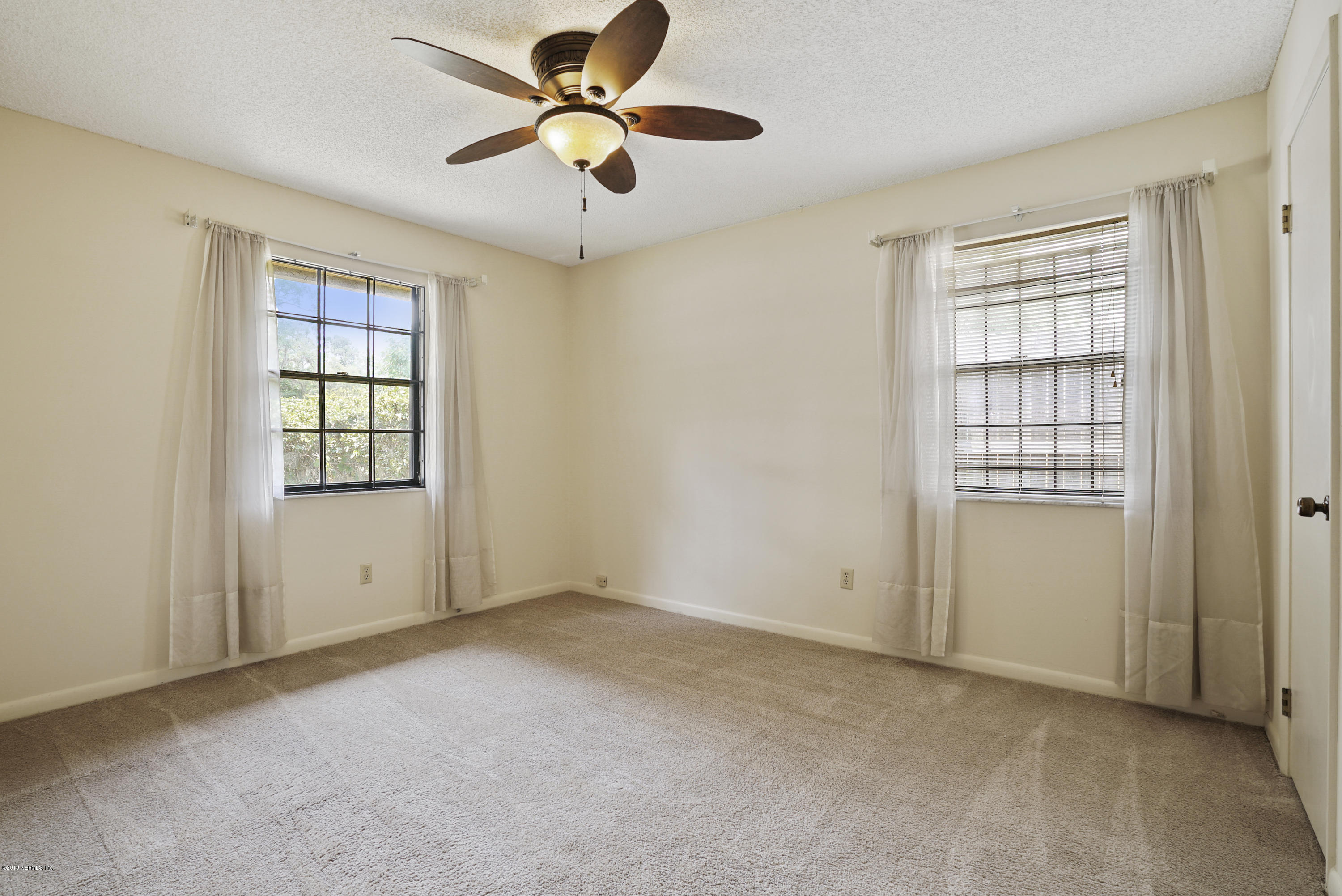 5353 Hickson Road Jacksonville, FL 32207 - Photo 14 of 18 an empty room with windows and fan