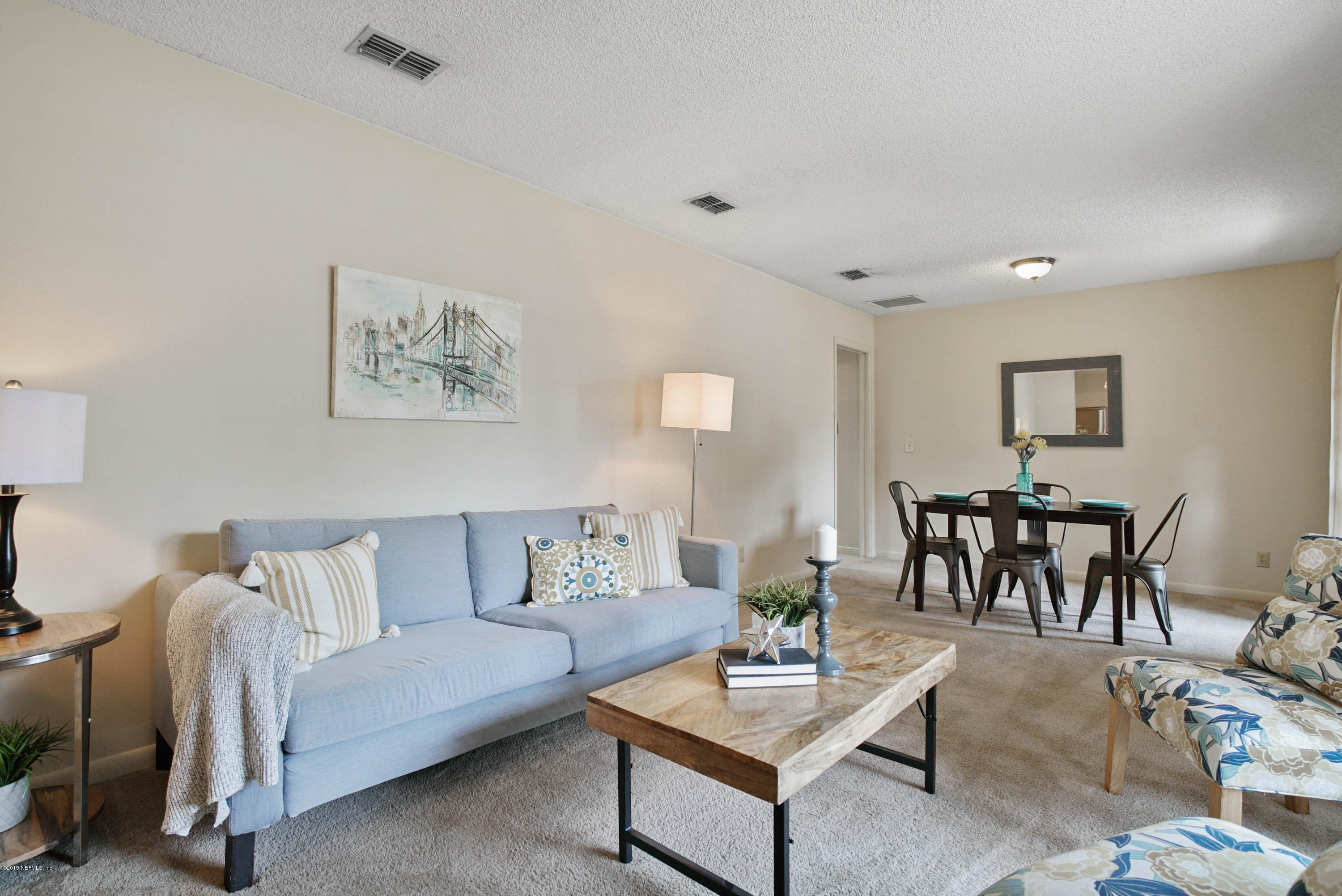 5353 Hickson Road Jacksonville, FL 32207 - Photo 2 of 18 a living room with furniture and a dining table with wooden floor
