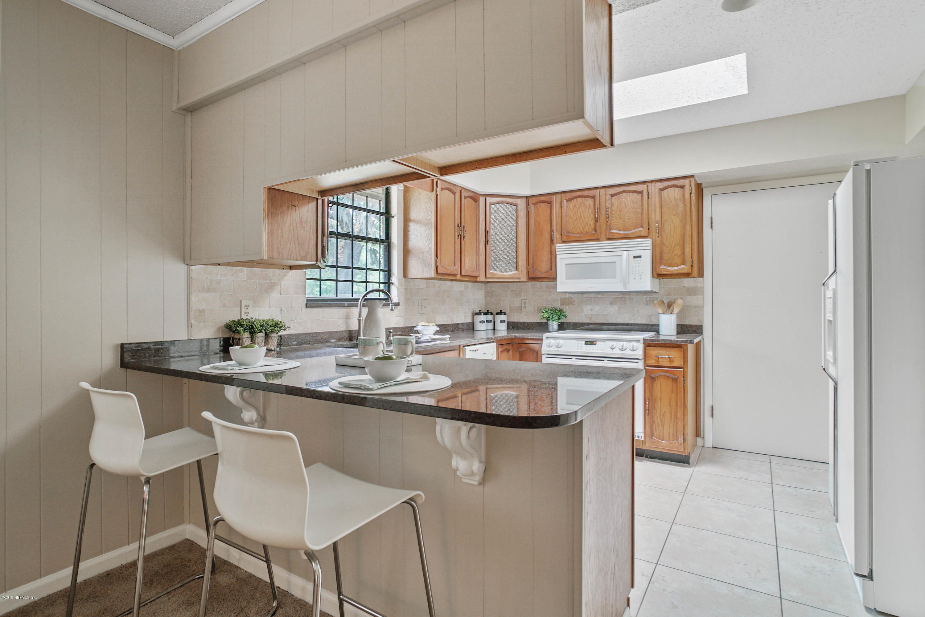 5353 Hickson Road Jacksonville, FL 32207 - Photo 8 of 18 a kitchen with appliances a sink and cabinets