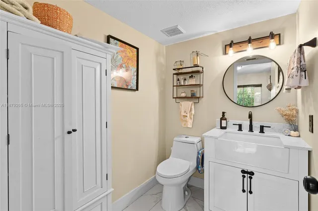 a bathroom with a toilet a sink and mirror