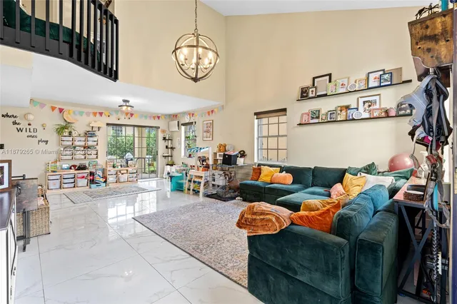 a living room with furniture kitchen view and a large window