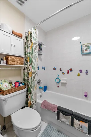 a white toilet sitting next to a bathroom sink and a bath tub