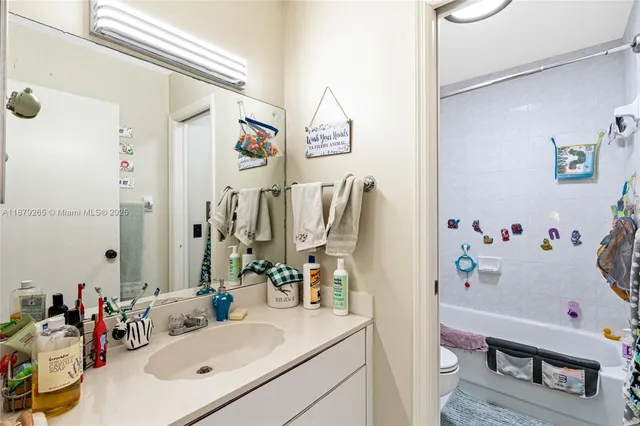 a bathroom with a sink vanity mirror and tub