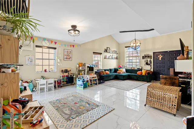 a living room with furniture a chandelier and a window