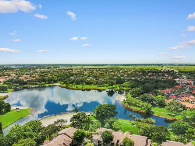 an aerial view of ocean and residential houses with outdoor space