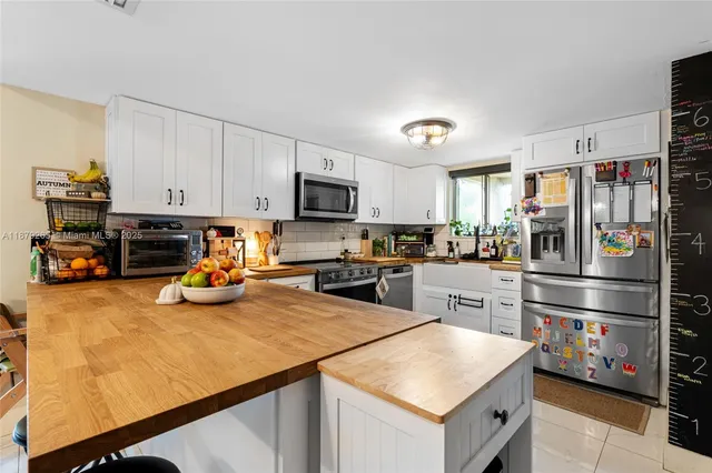 a kitchen with a refrigerator a stove a microwave and wooden floor