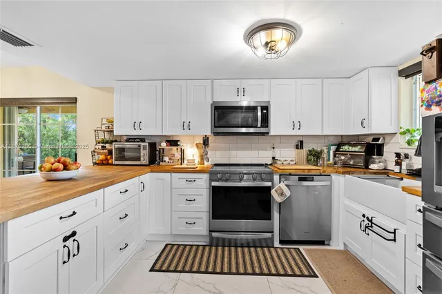 a kitchen with granite countertop a stove sink and cabinets