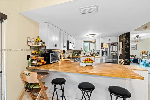 a kitchen with stainless steel appliances granite countertop a sink and a refrigerator