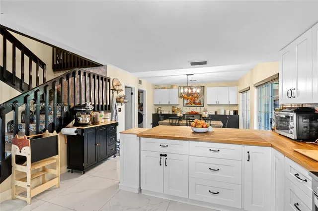 a view of a kitchen that has a lot of cabinets and wooden floor