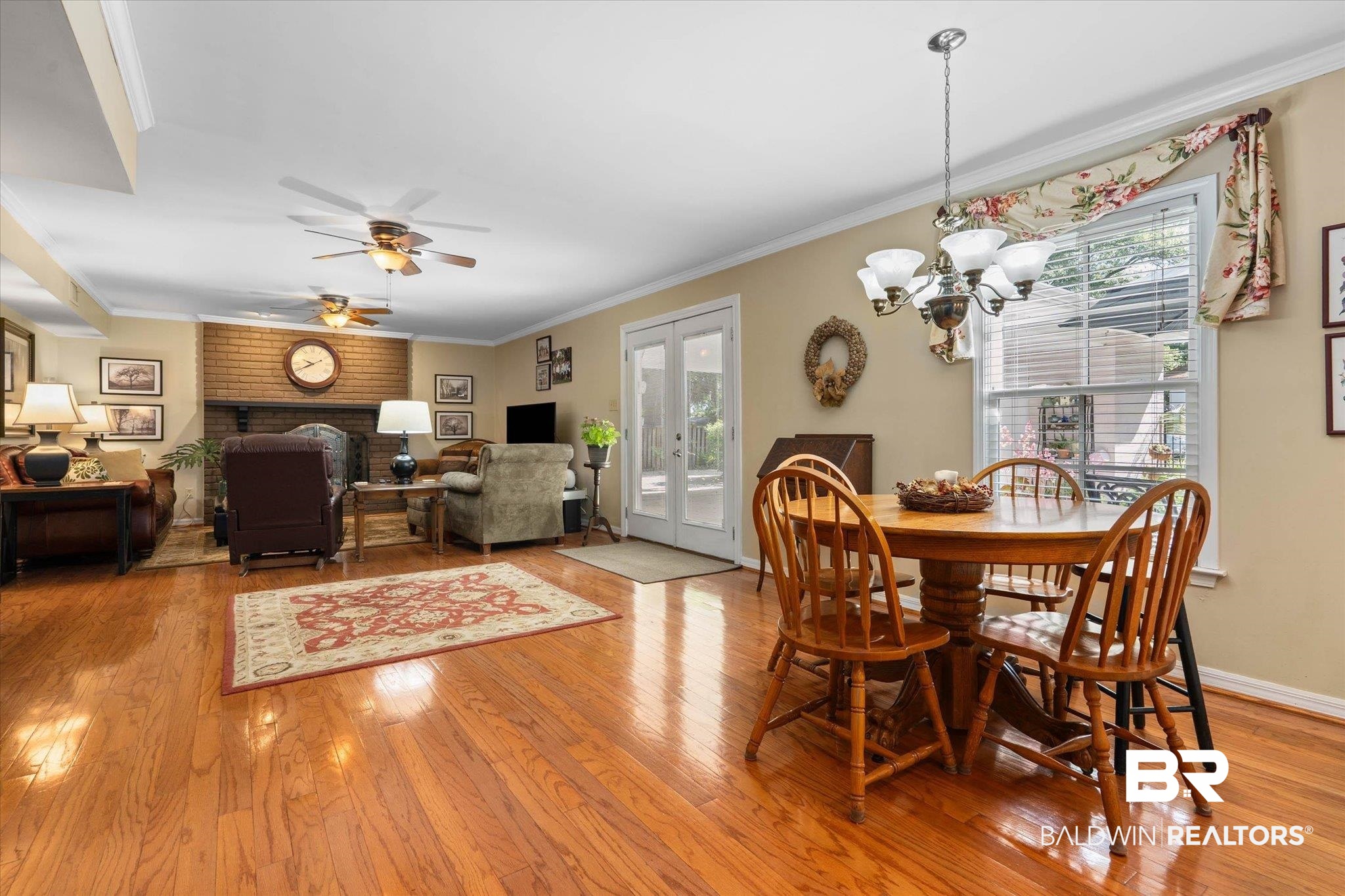 559 East Cumberland Road Mobile, AL 36608 - Photo 14 of 48 Dining space featuring a brick fireplace, light wood finished floors, french doors, ornamental molding, and ceiling fan