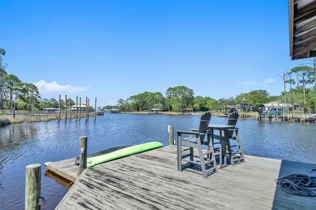 a kitchen with stainless steel appliances kitchen island granite countertop a table chairs a stove a microwave and cabinets