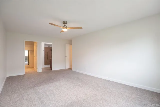 a view of an empty room with a ceiling fan