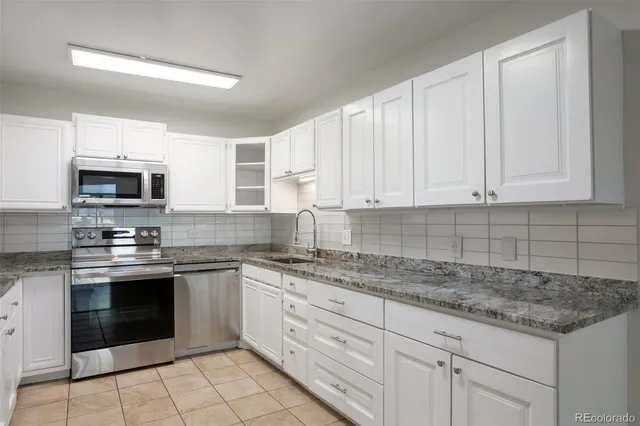 a kitchen with stainless steel appliances granite countertop a sink and a stove