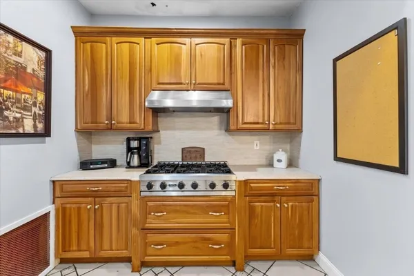 a kitchen with stainless steel appliances wooden cabinets and a stove top oven