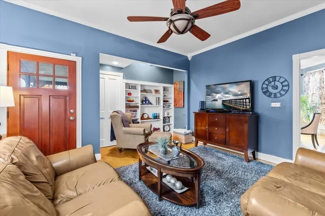 a living room with furniture a ceiling fan and a window
